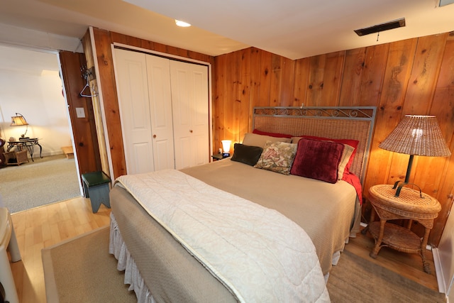 bedroom with wood walls, a closet, and carpet floors