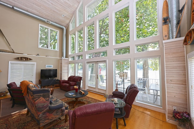 living room featuring high vaulted ceiling, a wealth of natural light, wood-type flooring, and wooden ceiling