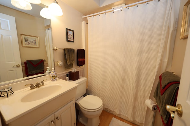 bathroom with hardwood / wood-style floors, a shower with curtain, toilet, and vanity