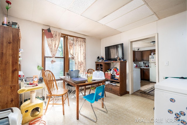 tiled dining area with a paneled ceiling