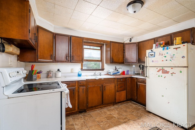 kitchen featuring sink, crown molding, white appliances, and light tile patterned floors