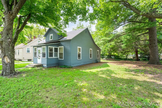 rear view of house featuring a lawn