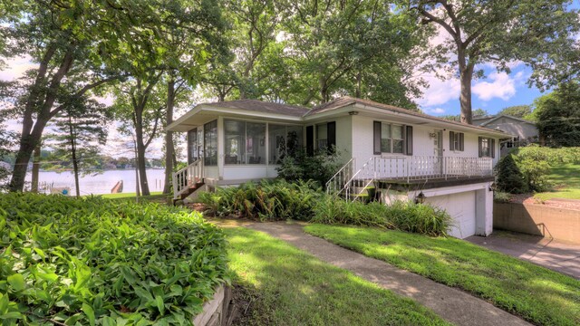 ranch-style home with a water view, a garage, and a sunroom