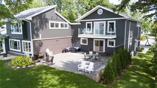 back of property with a yard, a patio area, a balcony, and central air condition unit