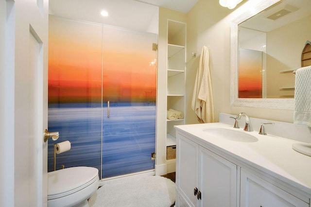 bathroom featuring built in shelves, vanity, and toilet