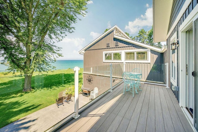 deck featuring a yard, a patio, and a water view