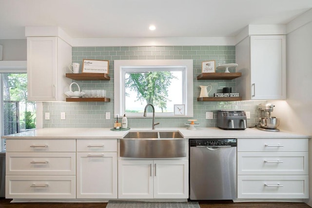 kitchen with sink, backsplash, stainless steel dishwasher, and white cabinets