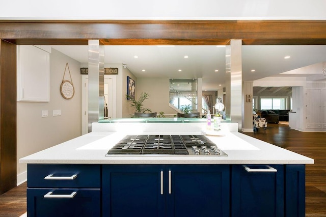 kitchen featuring blue cabinetry, dark wood-type flooring, a center island, and stainless steel gas cooktop