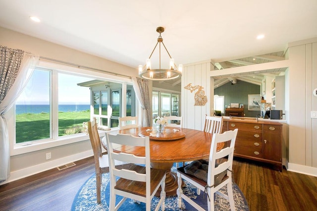 dining room featuring a water view, lofted ceiling, a chandelier, and dark hardwood / wood-style flooring