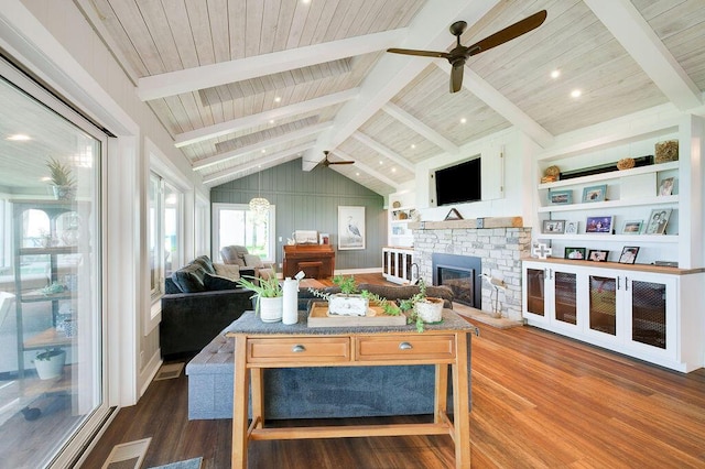 living room featuring a stone fireplace, vaulted ceiling with beams, wood-type flooring, wooden ceiling, and ceiling fan