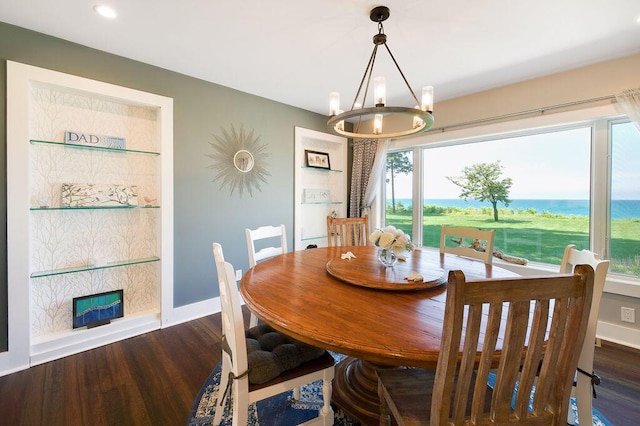 dining space featuring dark wood-type flooring and an inviting chandelier