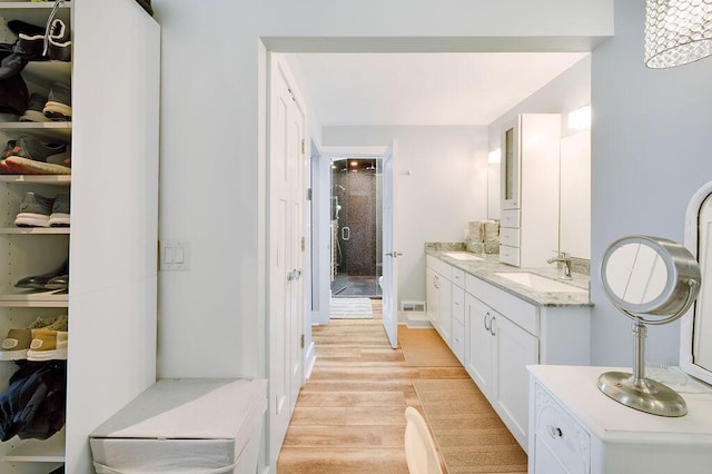 bathroom with vanity, hardwood / wood-style floors, and a shower with shower door