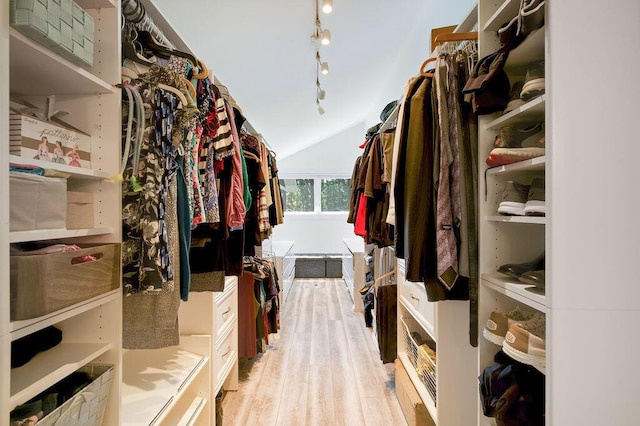 walk in closet with lofted ceiling and light hardwood / wood-style flooring