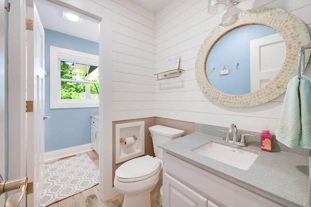 bathroom with wood-type flooring, vanity, and toilet