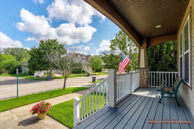 wooden terrace featuring a lawn