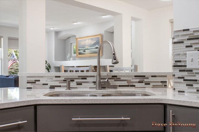 interior space with decorative backsplash and sink