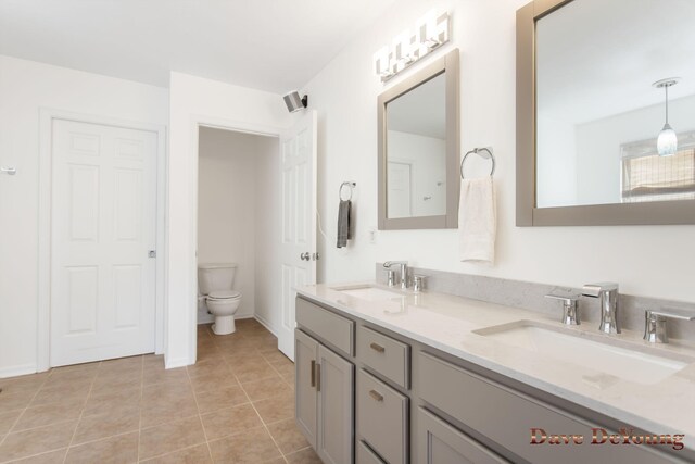 bathroom with double vanity, tile patterned flooring, and toilet