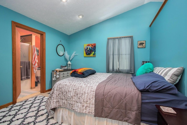 bedroom featuring vaulted ceiling, connected bathroom, and a textured ceiling