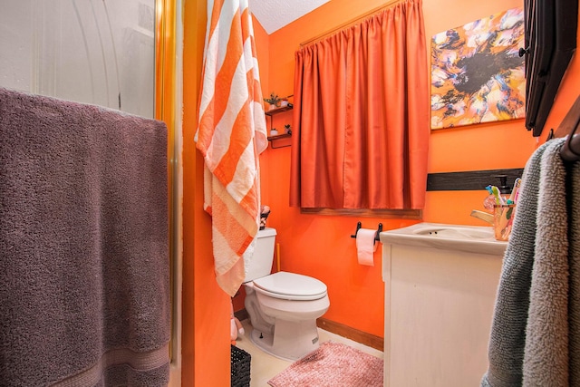 bathroom with vanity, toilet, a shower with shower curtain, and a textured ceiling