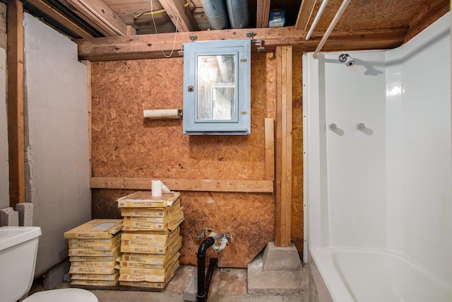 bathroom featuring a tub, concrete floors, and toilet