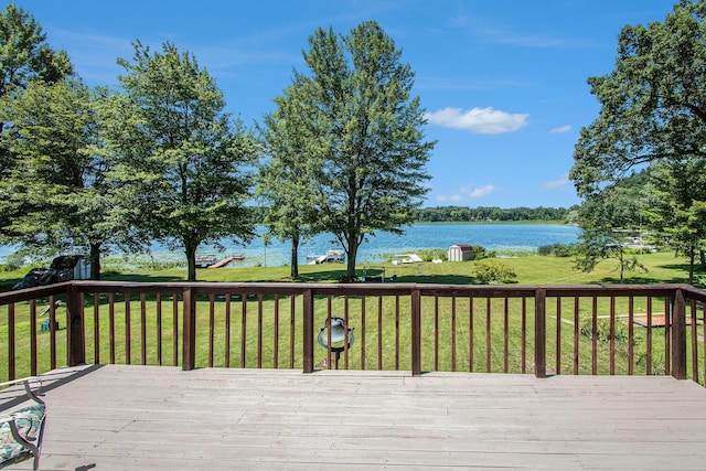 deck with a water view and a lawn