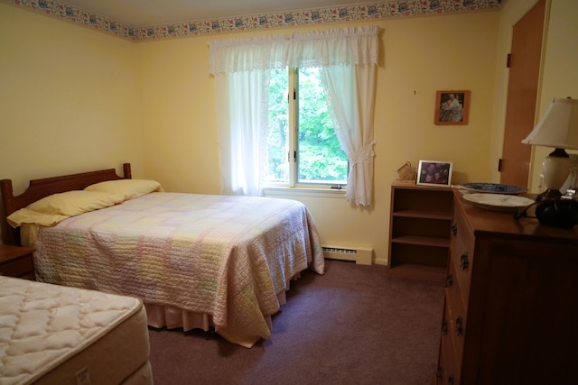 bedroom with dark carpet and a baseboard heating unit