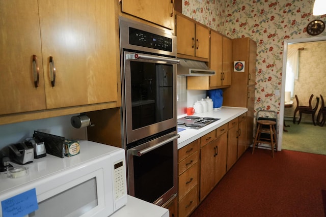 kitchen with appliances with stainless steel finishes and dark colored carpet