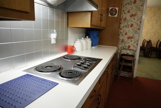 kitchen featuring custom exhaust hood, dark colored carpet, backsplash, and electric cooktop