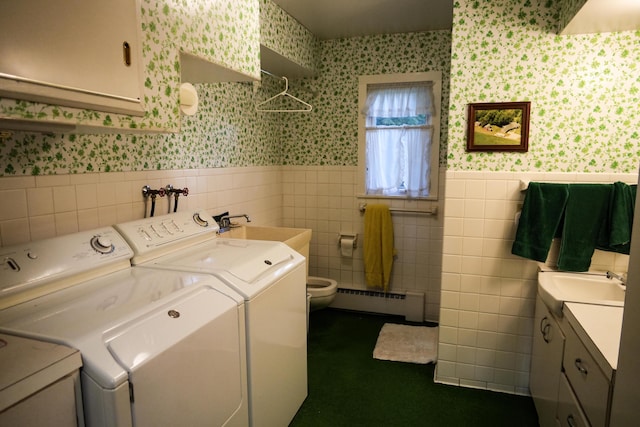 laundry area with a baseboard radiator, sink, and independent washer and dryer