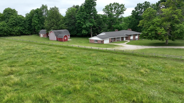 view of yard featuring a rural view and a storage shed