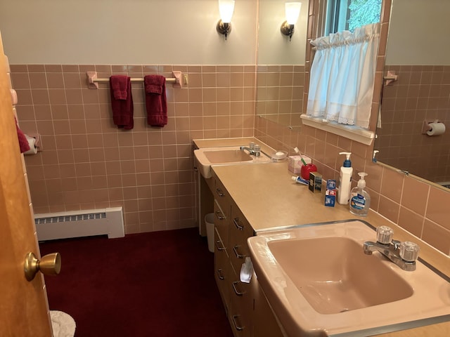 bathroom with a baseboard radiator, vanity, and tile walls