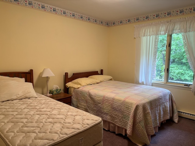 bedroom with a baseboard heating unit and dark colored carpet