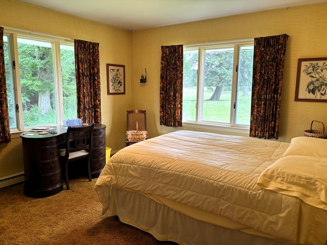 bedroom with carpet floors and a baseboard heating unit