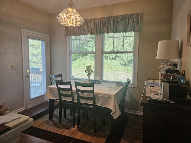 dining area featuring a healthy amount of sunlight, dark hardwood / wood-style floors, and a notable chandelier