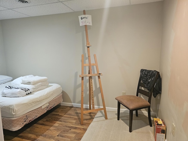 bedroom with a paneled ceiling and hardwood / wood-style floors