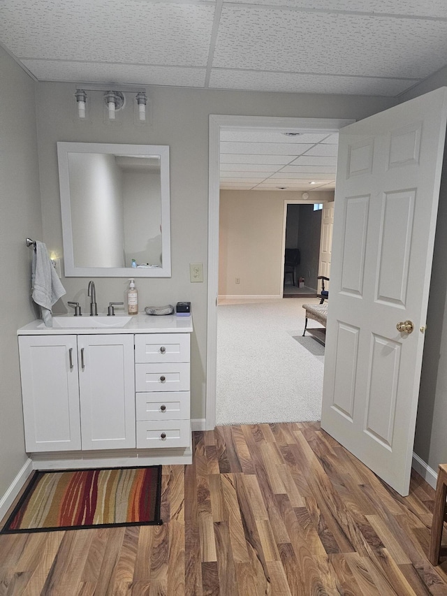 bathroom featuring a paneled ceiling, vanity, and hardwood / wood-style floors