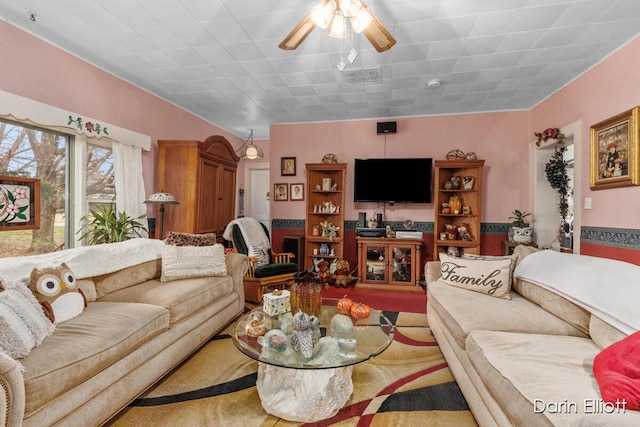 living area with ceiling fan and visible vents