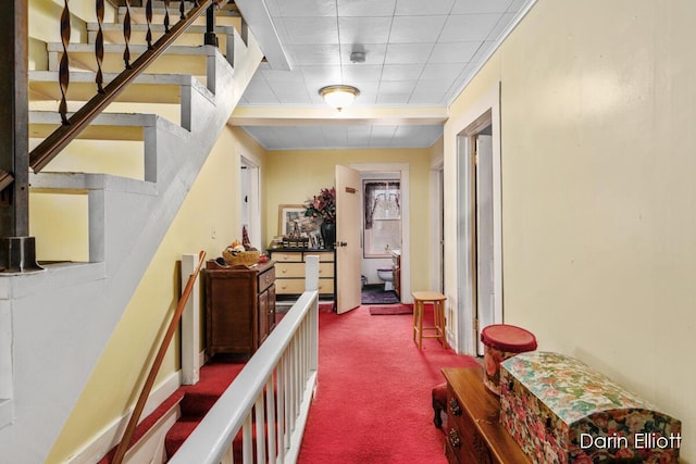hallway featuring carpet flooring and stairway