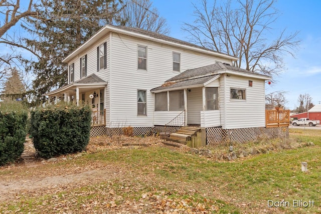 view of front of home with a front yard and a sunroom