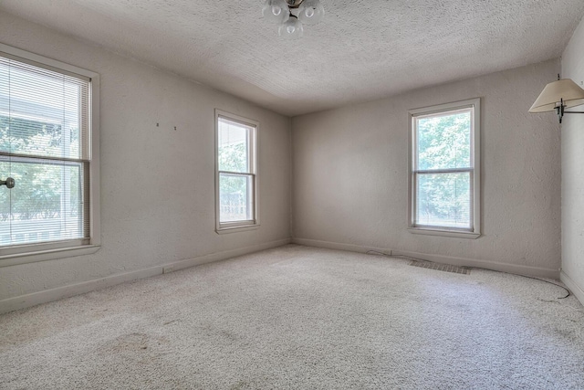 carpeted spare room featuring a textured ceiling