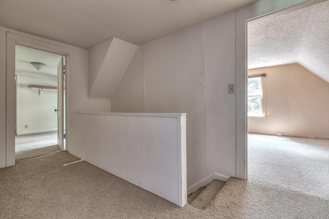 bonus room with lofted ceiling, light colored carpet, and a textured ceiling