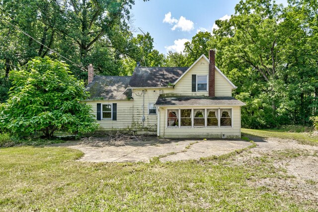 back of property with a patio area and a lawn