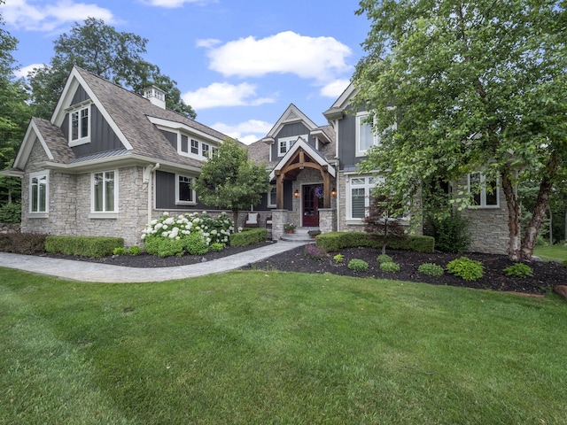 view of front of house featuring stone siding, a front lawn, and a standing seam roof