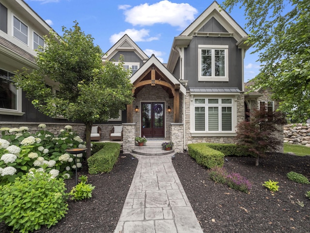 view of front of home featuring french doors, stone siding, metal roof, and a standing seam roof