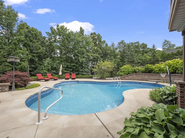 outdoor pool with a patio and fence