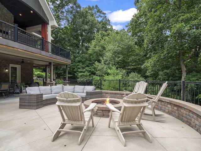 view of patio / terrace featuring an outdoor living space with a fire pit and a balcony