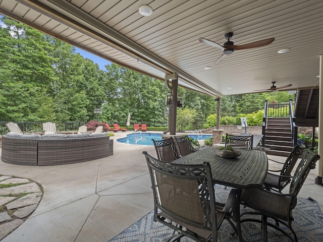 view of patio / terrace with stairway, an outdoor pool, outdoor dining area, and ceiling fan