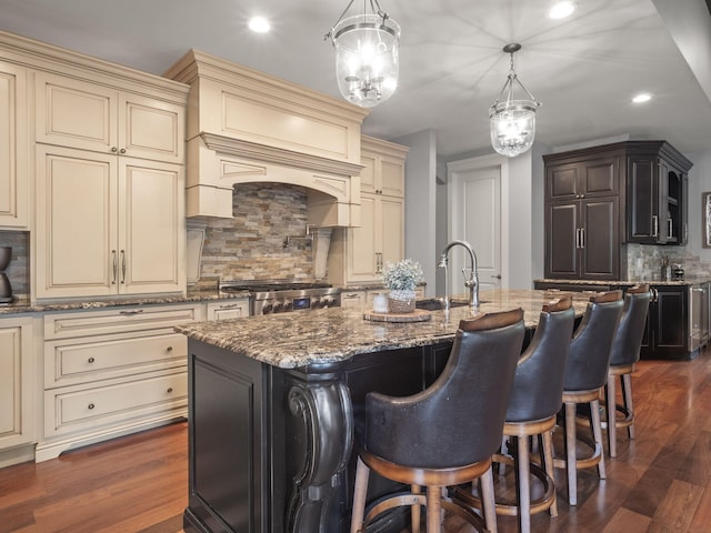 kitchen featuring dark wood finished floors, cream cabinetry, range, and a sink