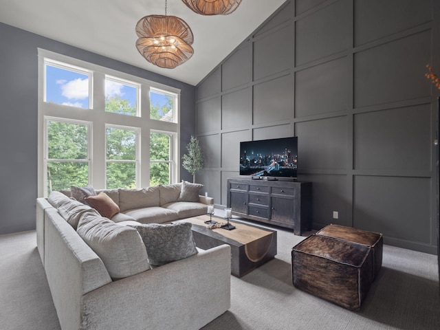 living area featuring light carpet, a decorative wall, and high vaulted ceiling