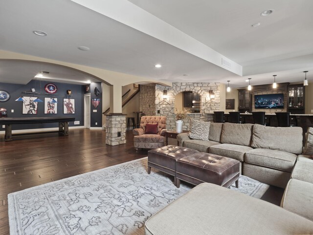 living area featuring visible vents, wood finished floors, recessed lighting, arched walkways, and bar